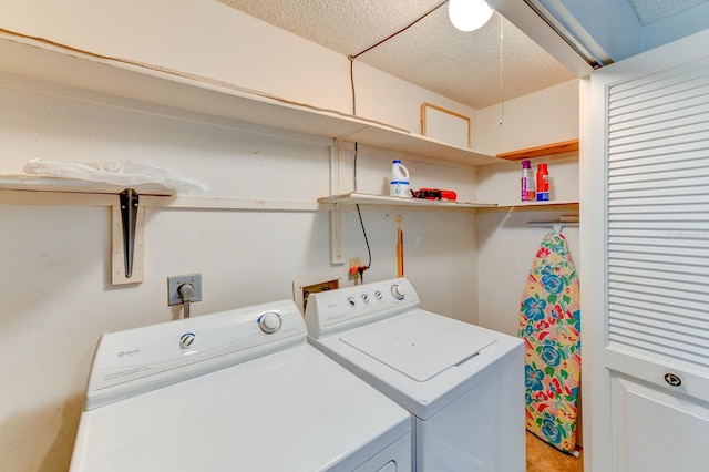 laundry area featuring washing machine and dryer and a textured ceiling