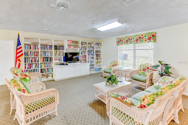 rec room with a textured ceiling and light carpet