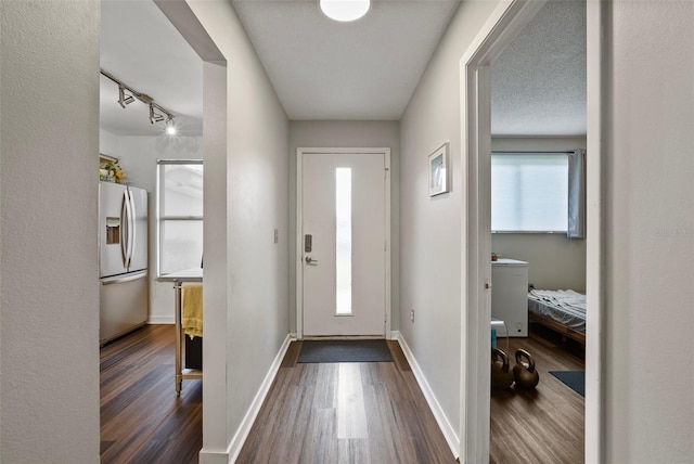 doorway to outside featuring a textured ceiling and dark wood-type flooring