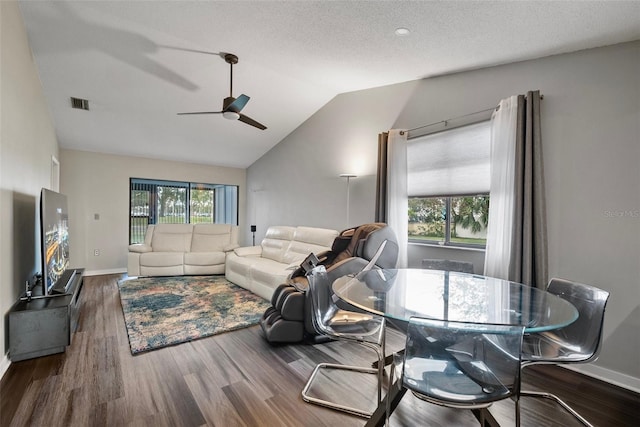 living room featuring ceiling fan, dark hardwood / wood-style flooring, a textured ceiling, and vaulted ceiling