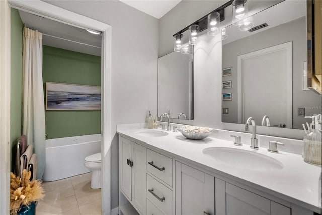 bathroom featuring tile patterned flooring, vanity, toilet, and a tub to relax in