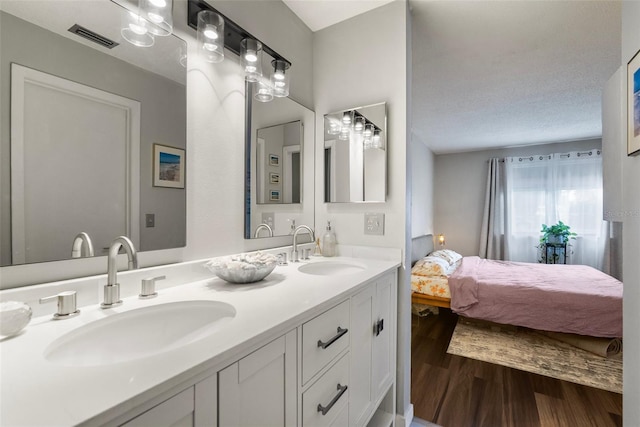 bathroom featuring vanity, wood-type flooring, and a textured ceiling