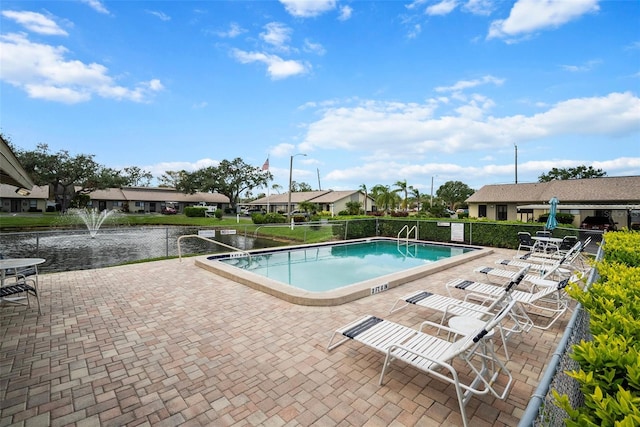 view of pool with a water view and a patio