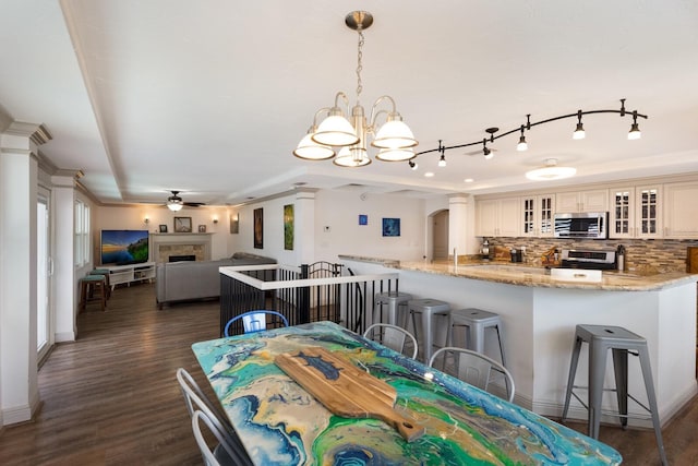 dining room featuring crown molding, dark hardwood / wood-style flooring, and ceiling fan with notable chandelier