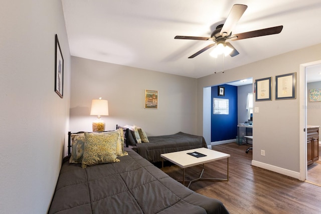 bedroom featuring ceiling fan, dark wood-type flooring, and connected bathroom