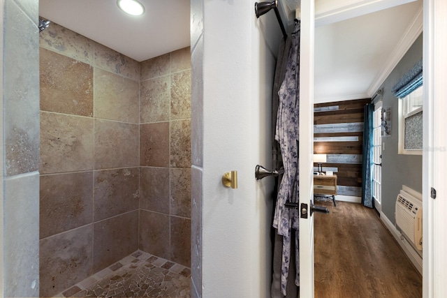 bathroom with hardwood / wood-style floors, a wall mounted air conditioner, crown molding, and a tile shower