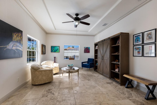 living area featuring a barn door, ceiling fan, and crown molding