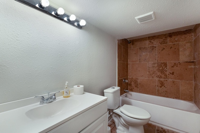 full bathroom with toilet, vanity, a textured ceiling, and tiled shower / bath