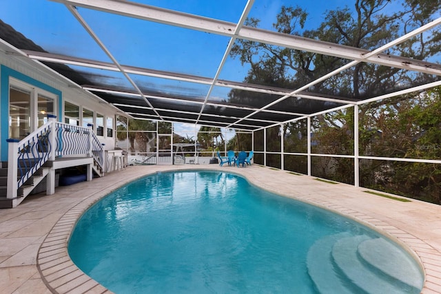 view of swimming pool featuring glass enclosure and a patio area