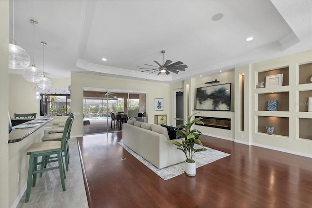 575 Fore Dr, Bradenton, FL 34208 - living room with a tray ceiling, ornamental molding, wood finished floors, ceiling fan, and built in features
