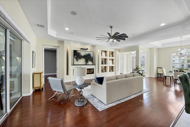 575 Fore Dr, Bradenton, FL 34208 - living area with a raised ceiling, dark wood-style floors, built in shelves, recessed lighting, and a chandelier