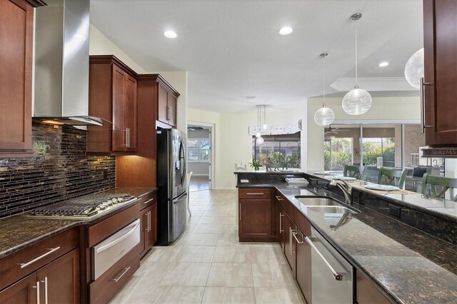 575 Fore Dr, Bradenton, FL 34208 - kitchen with stainless steel appliances, wall chimney exhaust hood, a sink, a warming drawer, and decorative backsplash