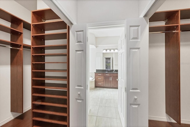 spacious closet with light tile patterned floors and sink