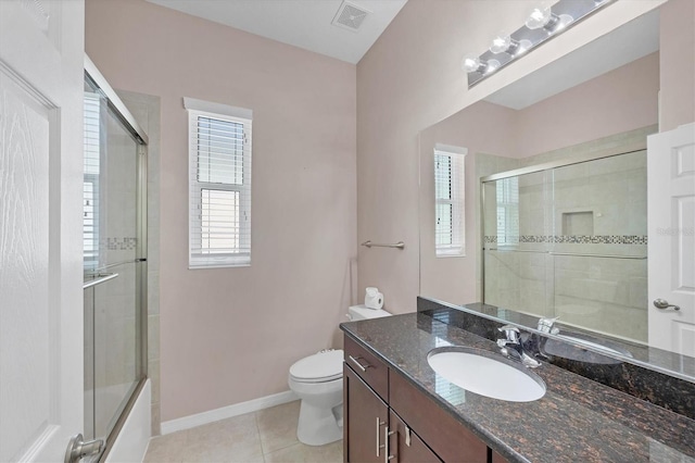 full bathroom featuring tile patterned floors, shower / bath combination with glass door, vanity, and toilet