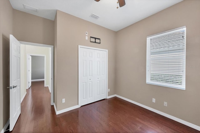 unfurnished bedroom with ceiling fan, a closet, and dark hardwood / wood-style floors