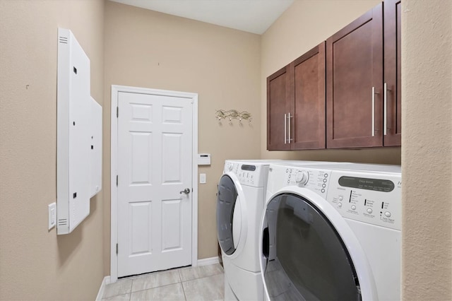 washroom with washer and clothes dryer, light tile patterned flooring, cabinets, and electric panel