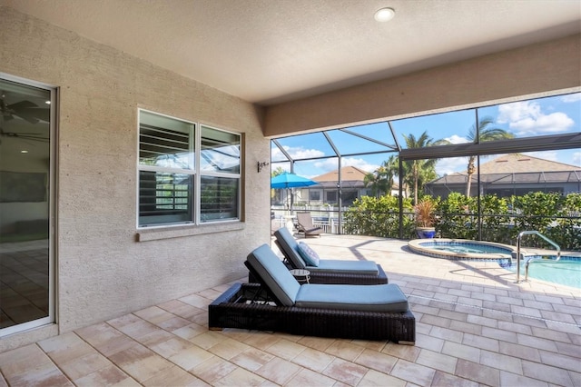 view of patio / terrace featuring glass enclosure and a pool with hot tub