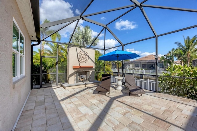 view of patio with a lanai and exterior fireplace