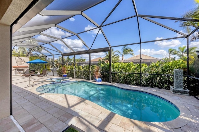 view of pool featuring a lanai, an in ground hot tub, and a patio