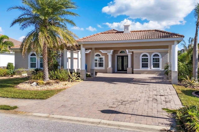 575 Fore Dr, Bradenton, FL 34208 - rear view of property featuring a tile roof, french doors, stucco siding, a chimney, and driveway