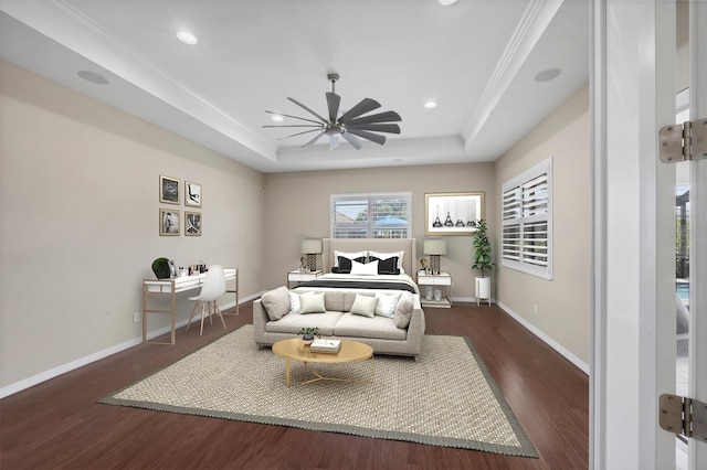 bedroom with ceiling fan, dark hardwood / wood-style flooring, crown molding, and a tray ceiling