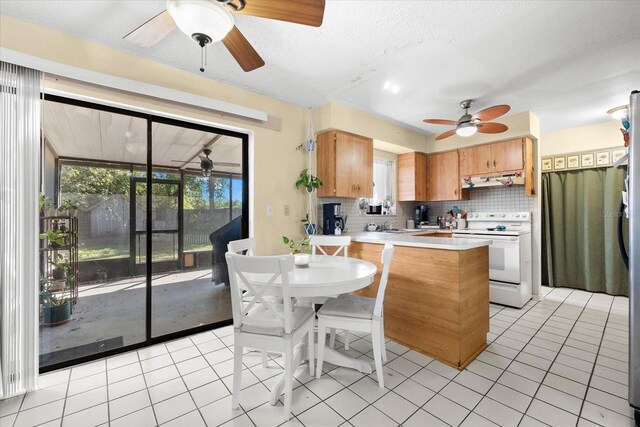 kitchen with decorative backsplash, light tile patterned floors, a textured ceiling, white electric range oven, and kitchen peninsula