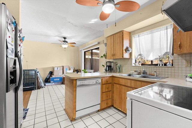 kitchen with tasteful backsplash, stainless steel fridge, stove, white dishwasher, and extractor fan