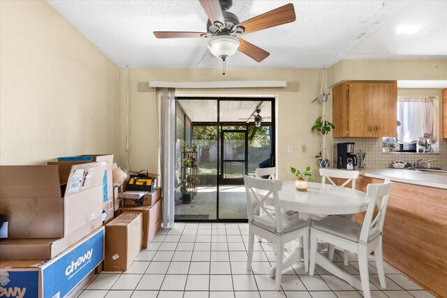 tiled dining room with ceiling fan and a textured ceiling