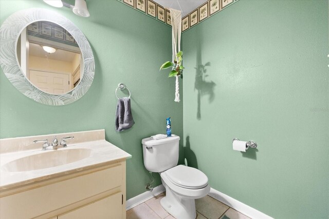 bathroom with tile patterned flooring, vanity, and toilet