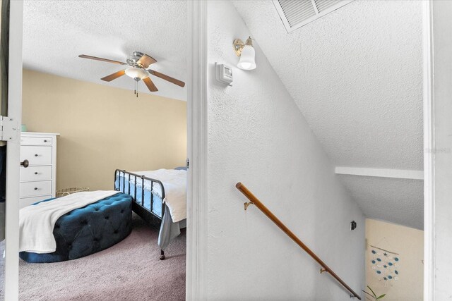 bedroom featuring carpet, a textured ceiling, ceiling fan, and lofted ceiling