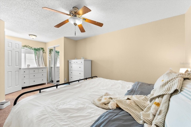 carpeted bedroom with ceiling fan and a textured ceiling