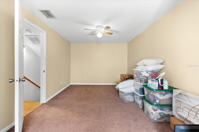 misc room featuring carpet flooring, ceiling fan, and a textured ceiling