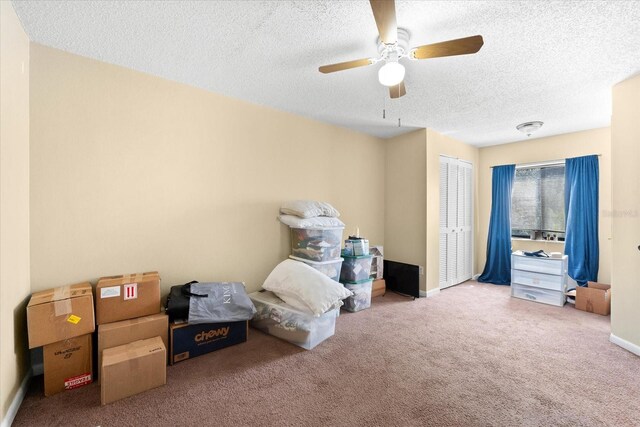 bedroom featuring carpet, ceiling fan, a textured ceiling, and a closet