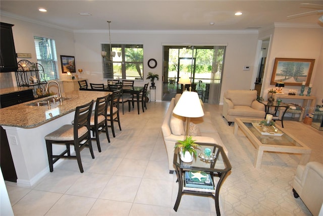 tiled living room featuring ceiling fan, sink, and crown molding