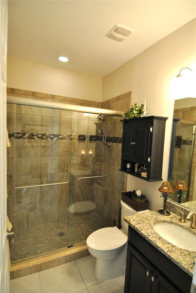 bathroom featuring walk in shower, toilet, vanity, and tile patterned floors