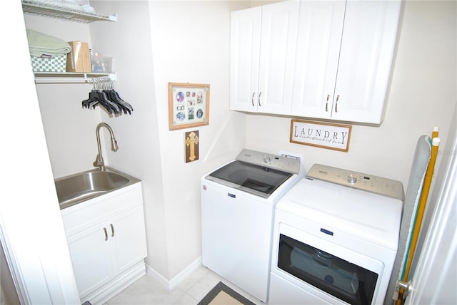 clothes washing area with cabinets, sink, washer and dryer, and light tile patterned floors