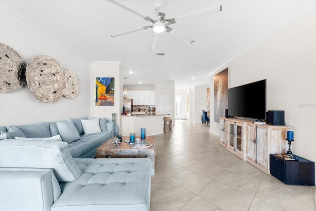 living room featuring light tile patterned floors, ceiling fan, and crown molding