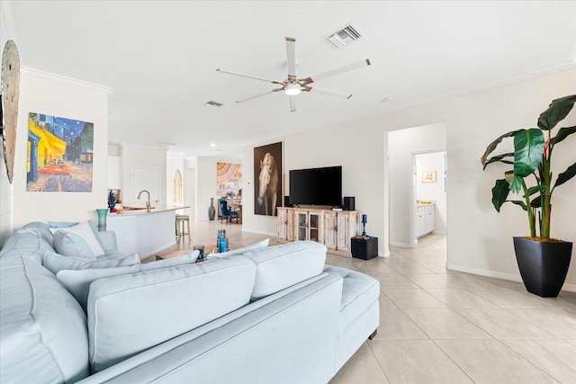 living room with light tile patterned floors, ceiling fan, ornamental molding, and sink