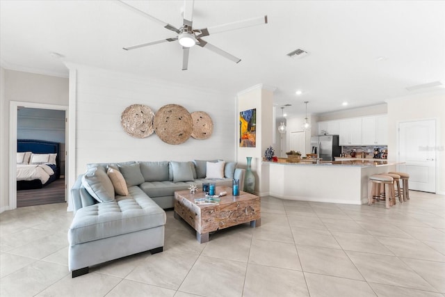 living room featuring ceiling fan, light tile patterned flooring, and ornamental molding