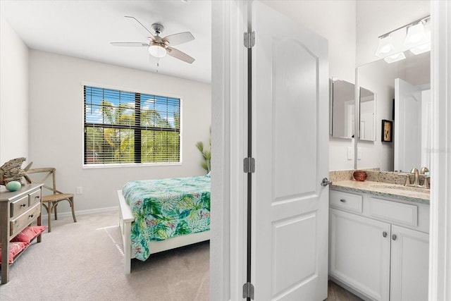 bedroom featuring ceiling fan, light colored carpet, and sink