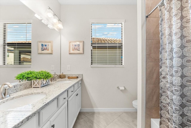 bathroom with toilet, vanity, tile patterned floors, and a healthy amount of sunlight