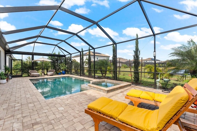 view of pool featuring glass enclosure, a patio area, and an in ground hot tub