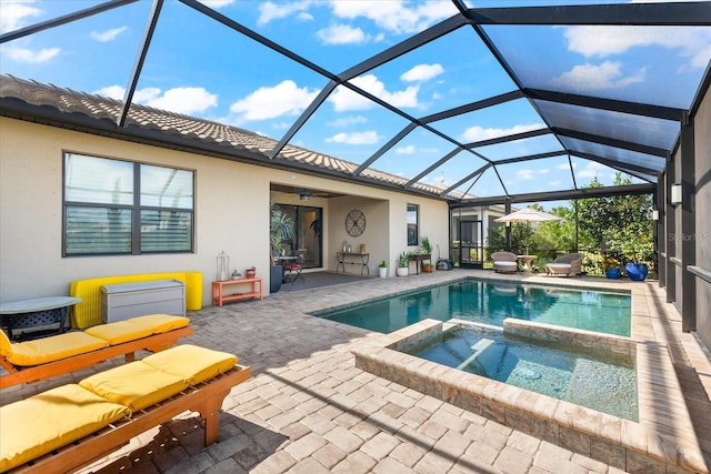 view of swimming pool with glass enclosure, an in ground hot tub, ceiling fan, and a patio