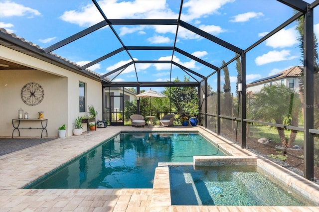 view of swimming pool with glass enclosure, an in ground hot tub, and a patio