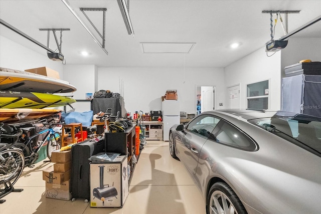 garage featuring white fridge and a garage door opener