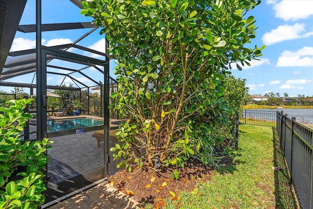 exterior space featuring a water view, glass enclosure, and a patio area