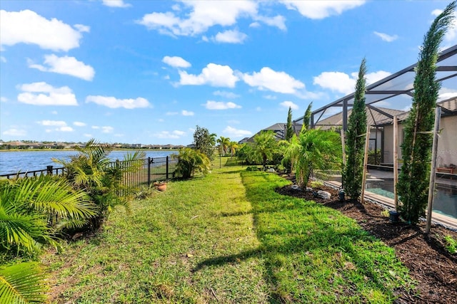 view of yard with a lanai and a water view