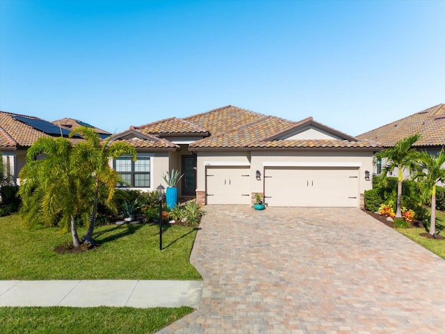 mediterranean / spanish home featuring a front lawn and a garage