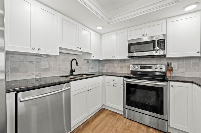 kitchen featuring a sink, light wood-type flooring, appliances with stainless steel finishes, and white cabinetry