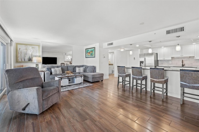 living area featuring visible vents and dark wood-type flooring